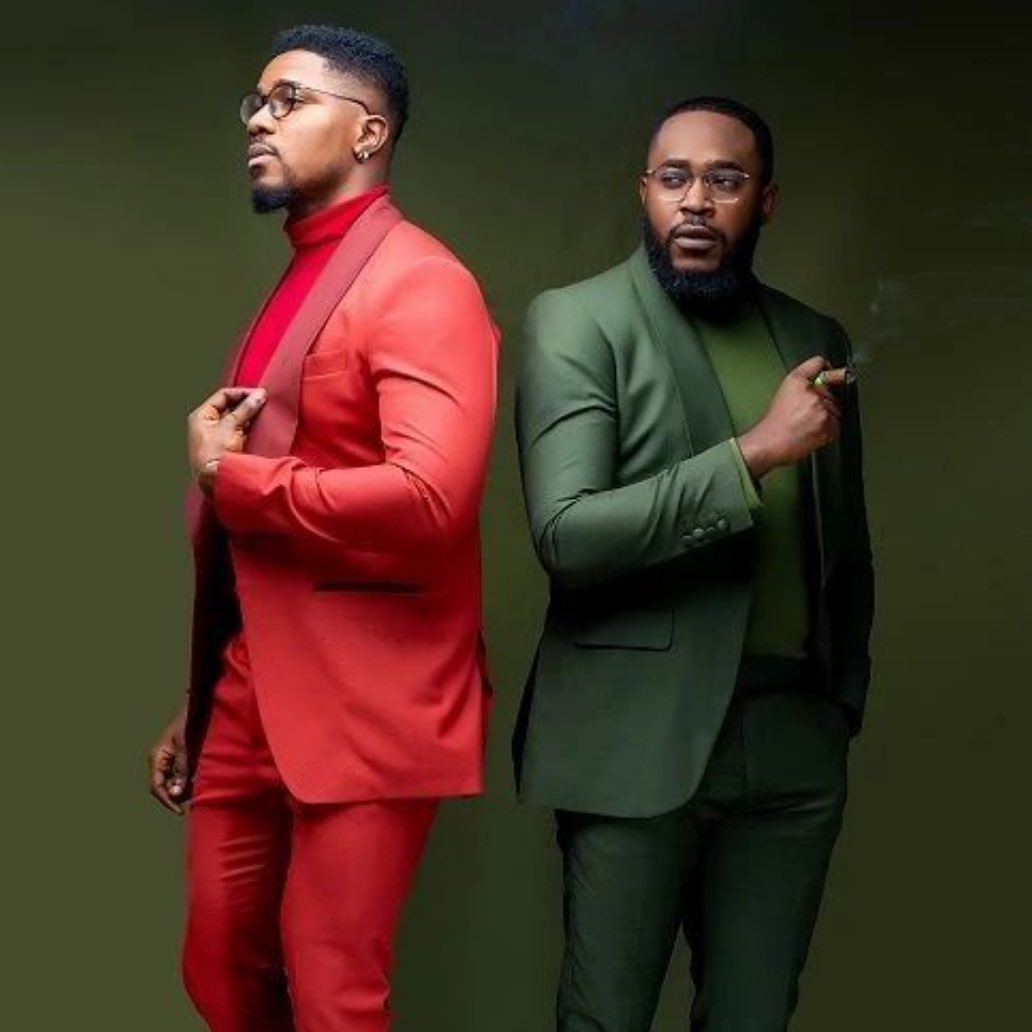 Two men wearing red and green suits with matching turtlenecks