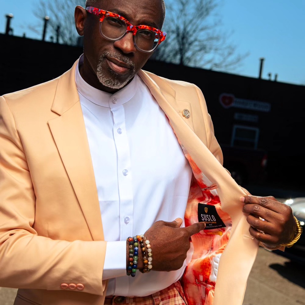 Man showing the lining of a peach Suslo Couture blazer