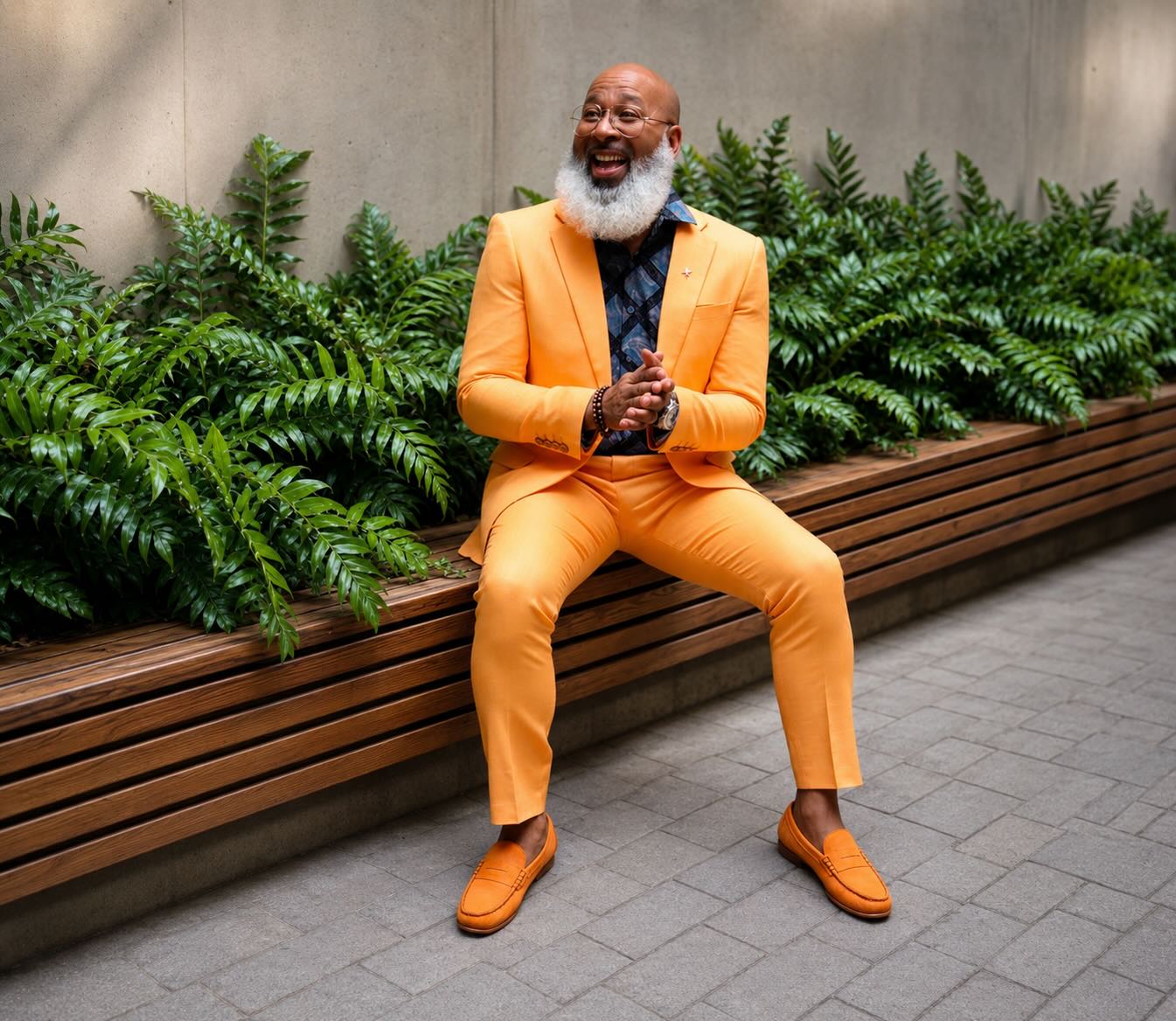 Man in a yellow suit seated on a bench